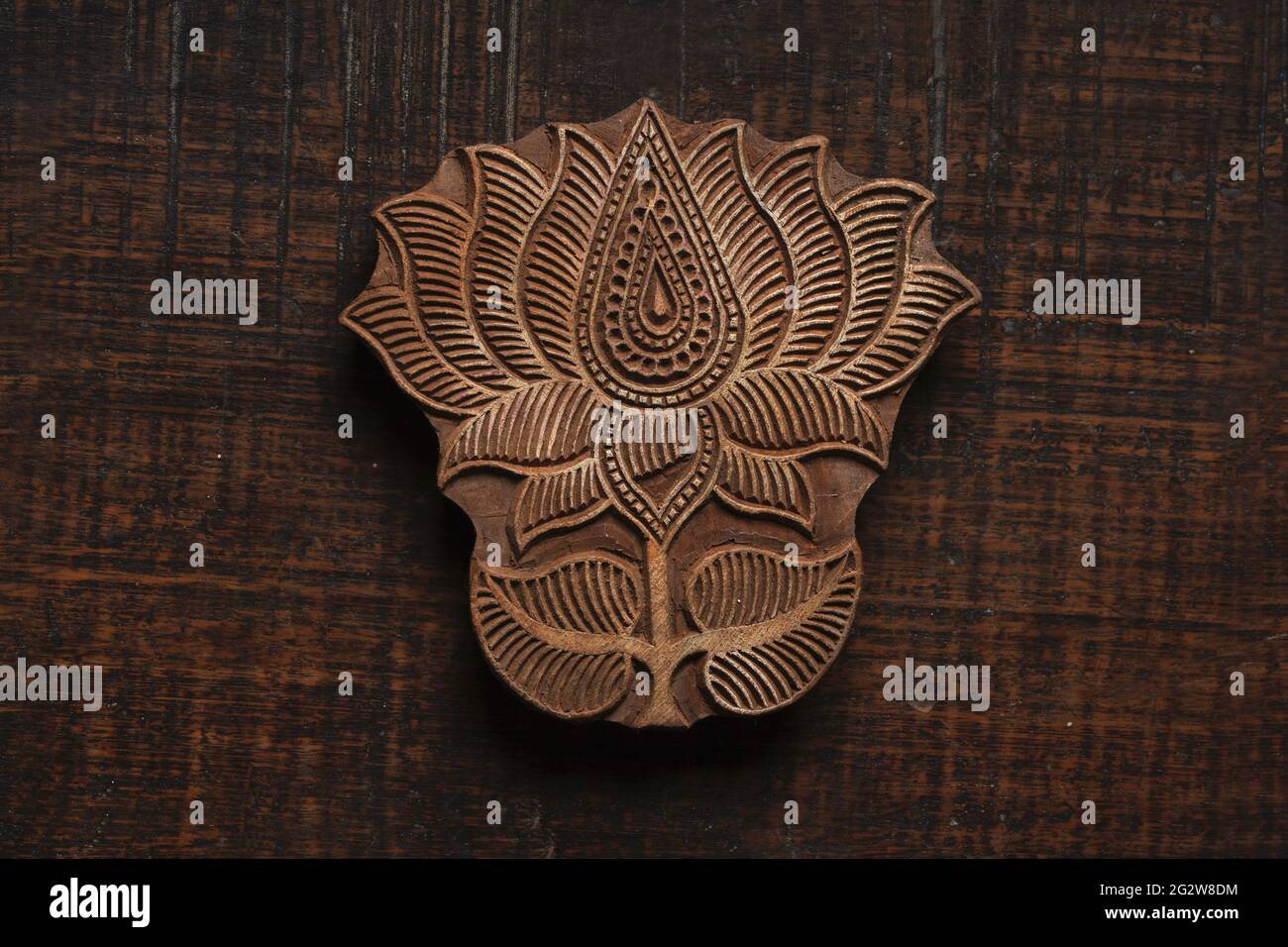 Lotus shape Indian wood block pattern for textile printing on rustic wood background. Block