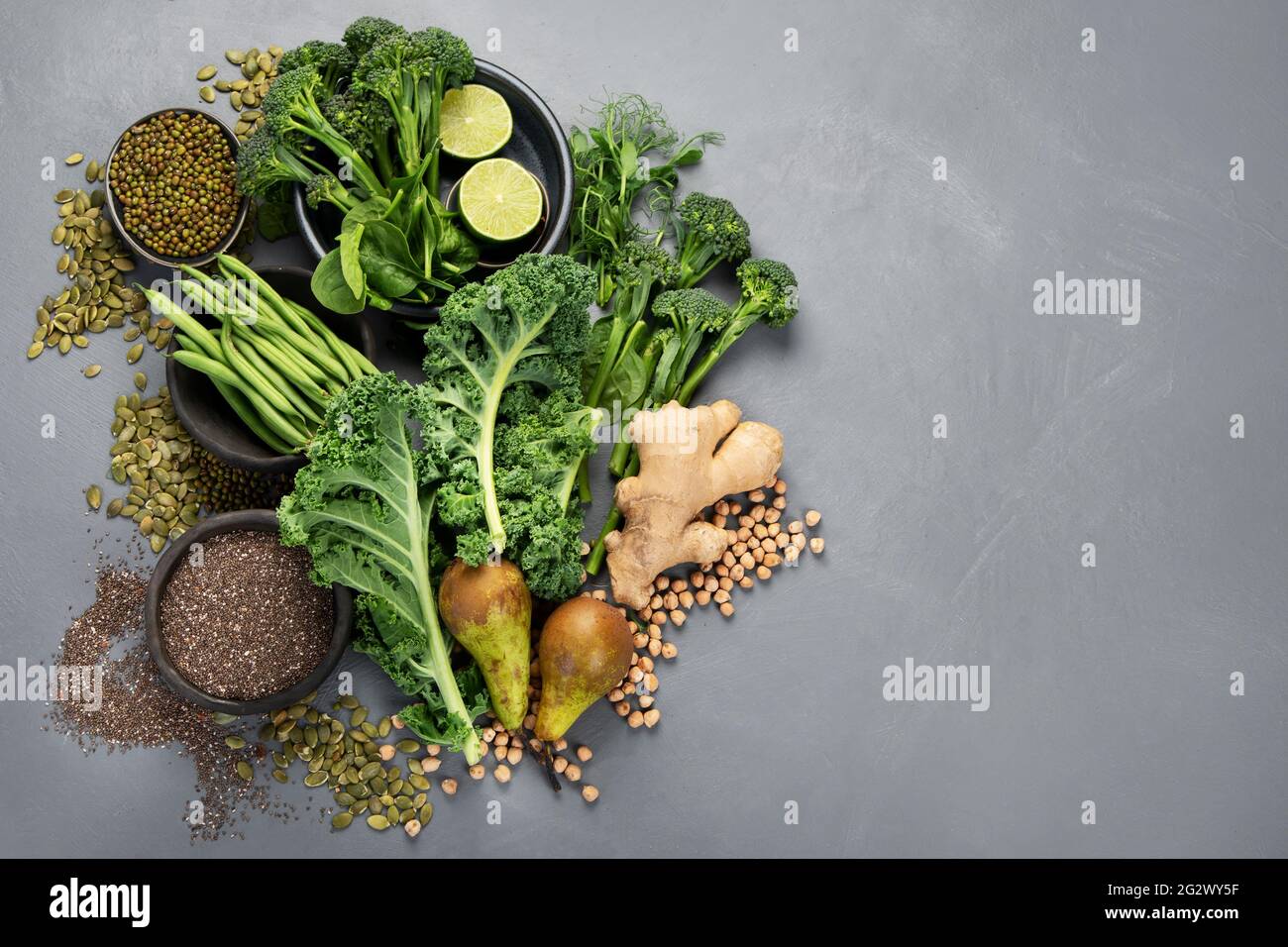 Assorted green vegetables and cereal on gray background. Healthy food ...