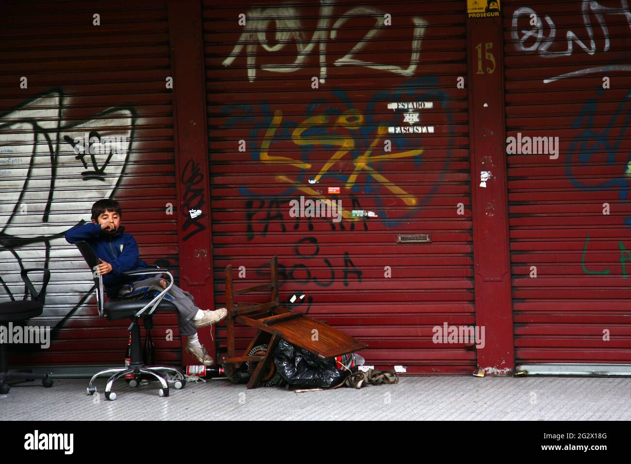 Street scenes from Buenos Aires  capital  of Argentina Garbage in a street and young child on an office chair Stock Photo