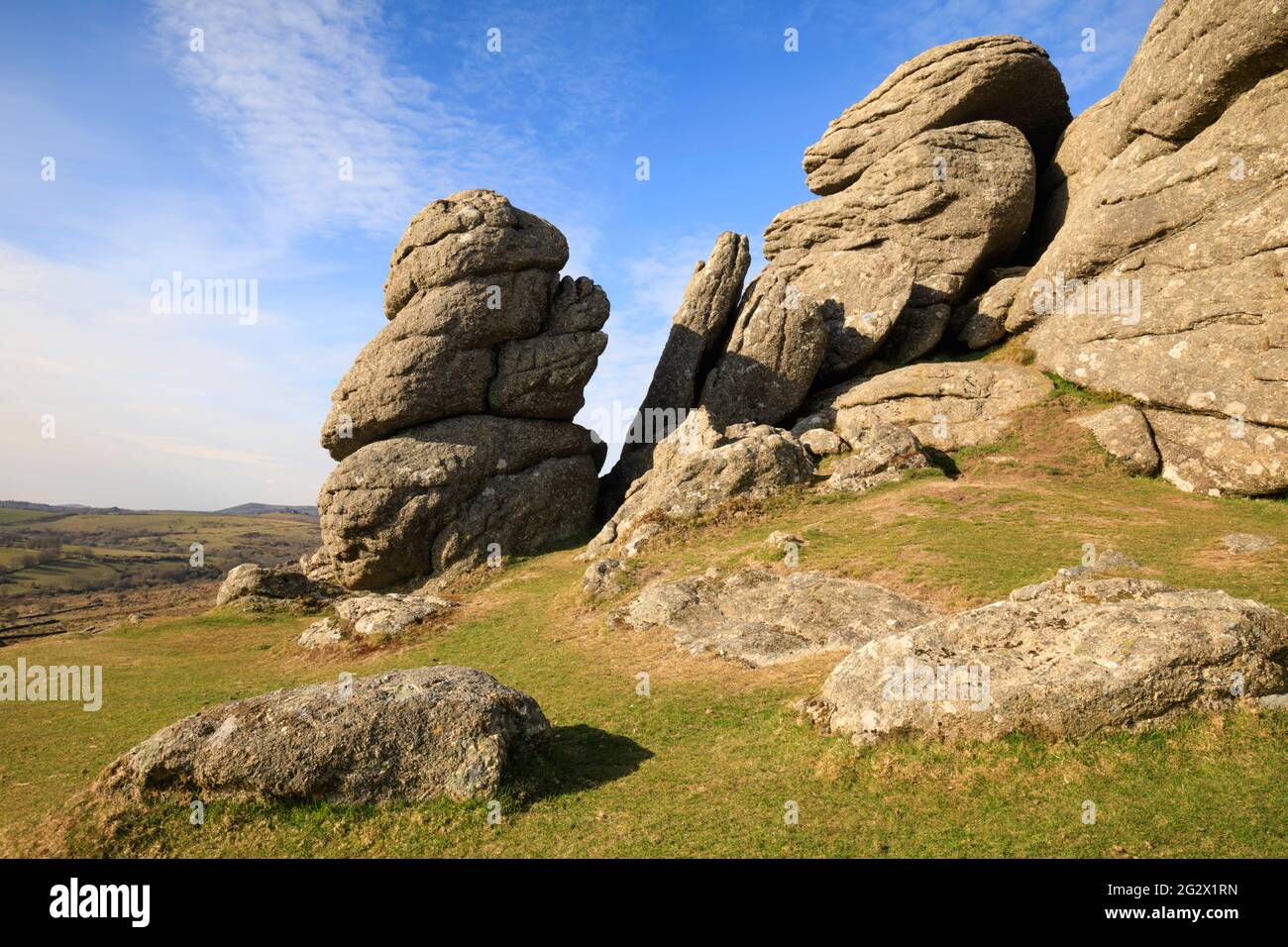 Rocks on Saddle Tor in the Dartmoor National Park with Hound Tor in the distance. Stock Photo