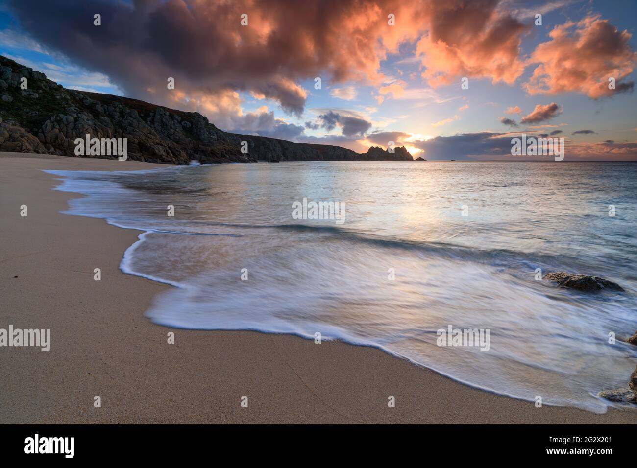 Logan Rock captured from Porthcurno Beach in Cornwall at sunrise. Stock Photo