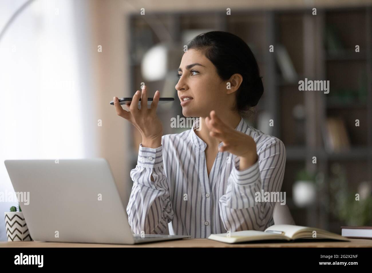 Young ethnic female scientist record work results using smartphone app Stock Photo