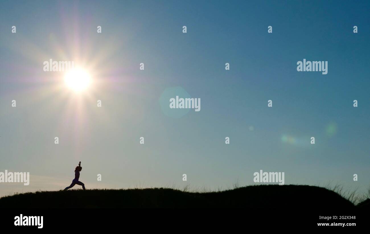 Silhouette of a woman in a yoga pose on sunset Stock Photo - Alamy