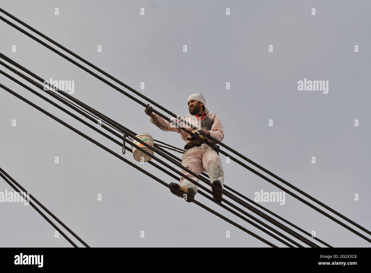 seaman, at 20 meters high, oiling/greasing  the wires of the crane Stock Photo