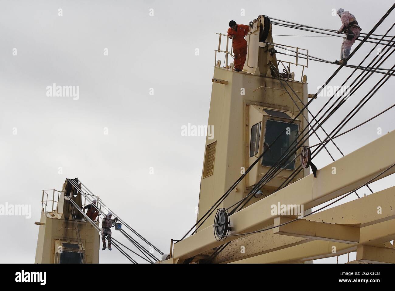 seaman, at 20 meters high, oiling/greasing the wires of the crane Stock
