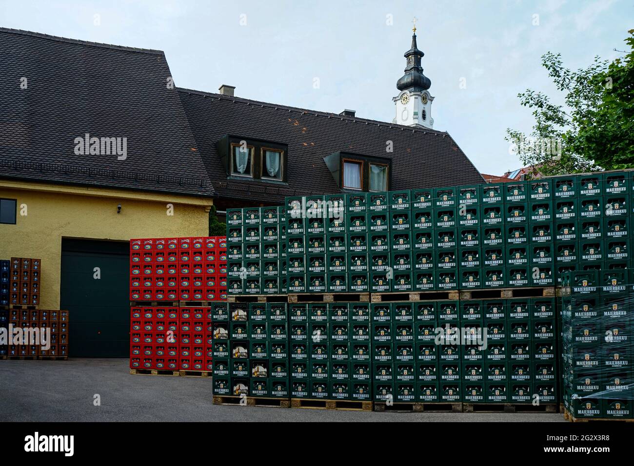 Beverage crates in the yard of a Bavarian beer brewery In Altomünster, district of Dachau nit view of a tower of a Catholic church. Stock Photo