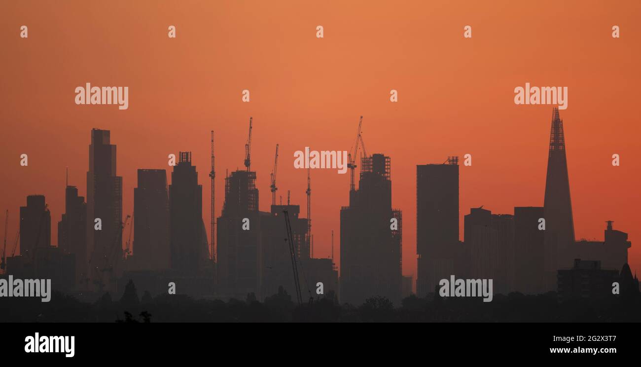 City of London skyline with construction cranes at sunrise on 13 June 2021, seen from Wimbledon in south west London, UK Stock Photo