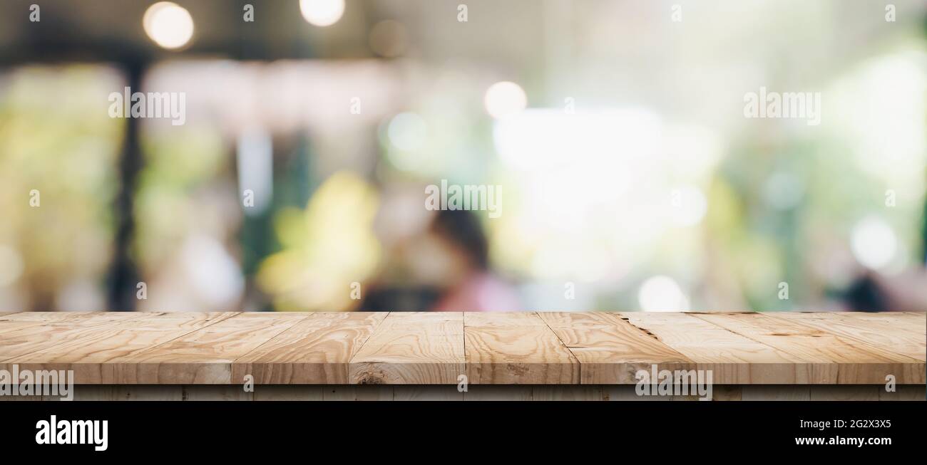 Empty wood table and blurred light table in coffee shop and cafe with ...