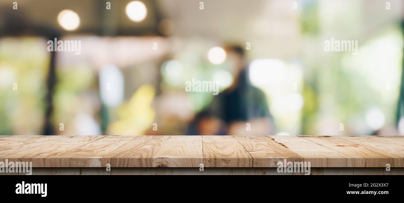 Empty wood table and blurred light table in coffee shop and cafe with ...