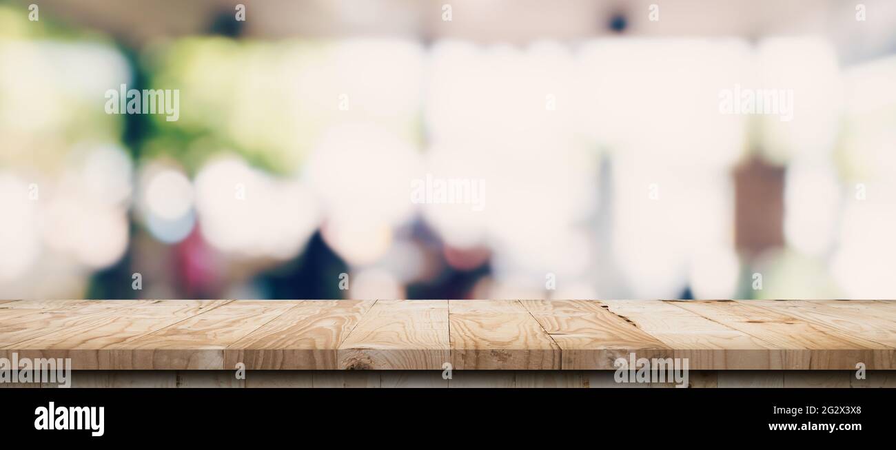 Empty wood table and blurred light table in coffee shop and cafe with ...