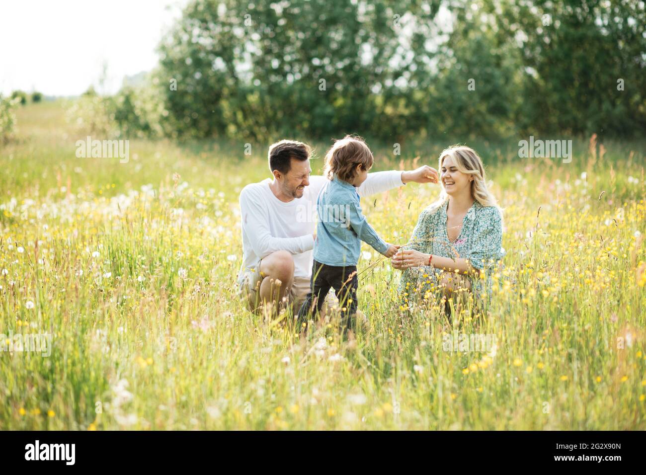 Happy family walking among flower in meadow, happy summer time, photo Stock Photo