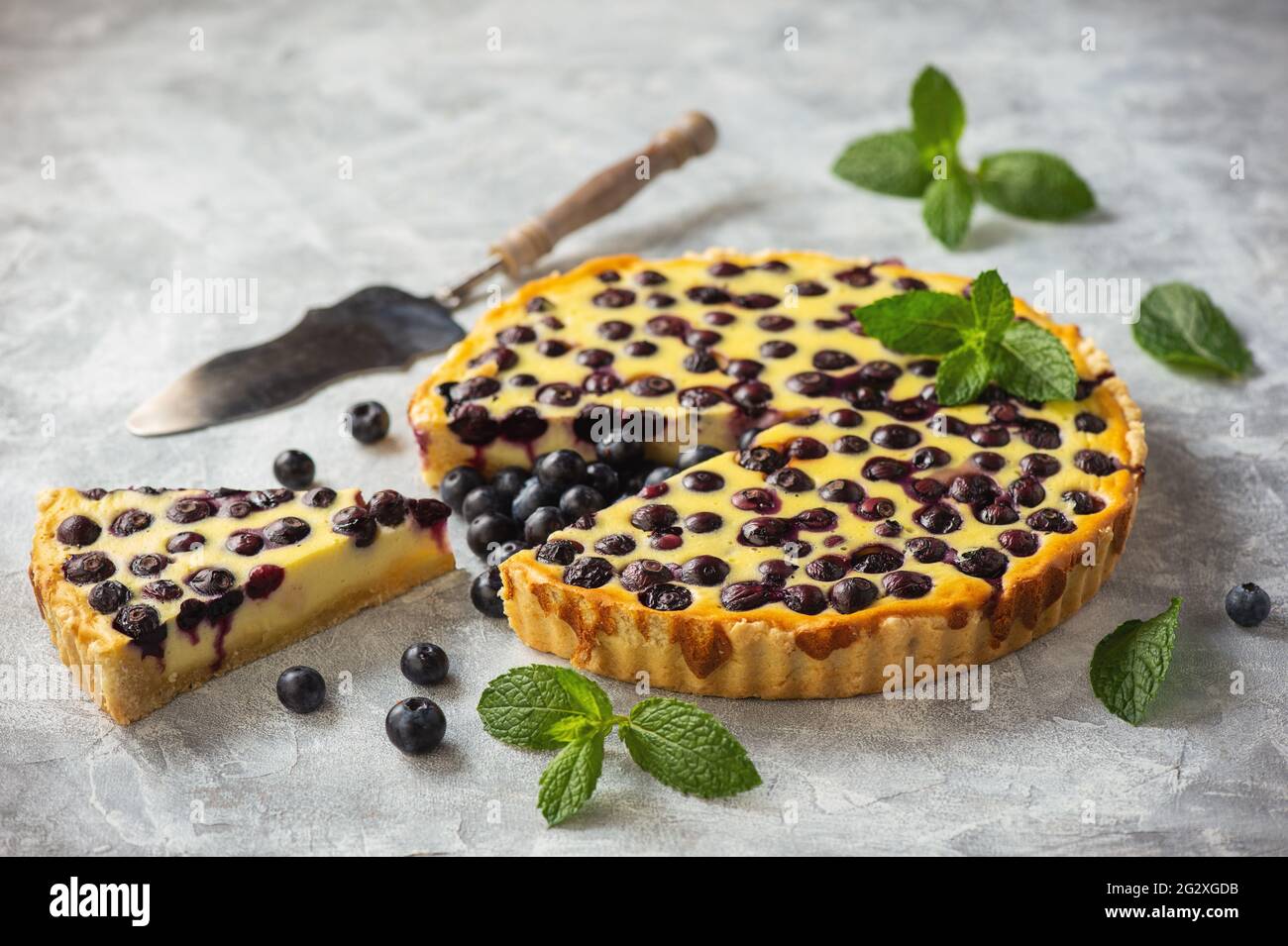 Homemade blueberry custard tart on light background. Stock Photo