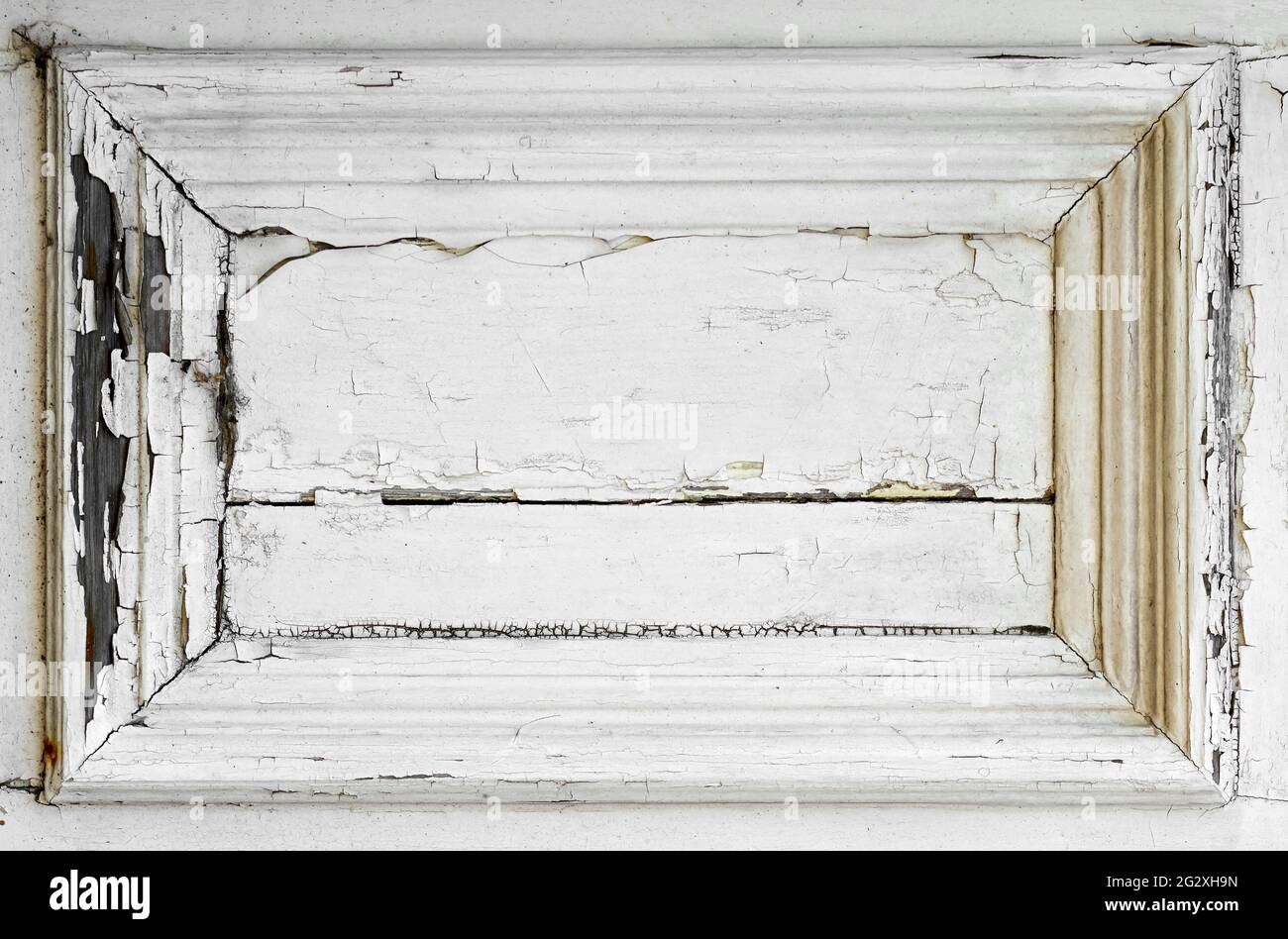 Heavily cracked paint on a white wooden door panel Stock Photo