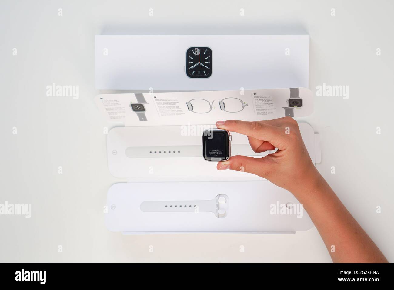 Unpacking of a new Apple Watch Series 6 40mm Silver Aluminum Case White Sport Band on White Background. Step five. Russia, Tatarstan, June 10, 2021. Stock Photo