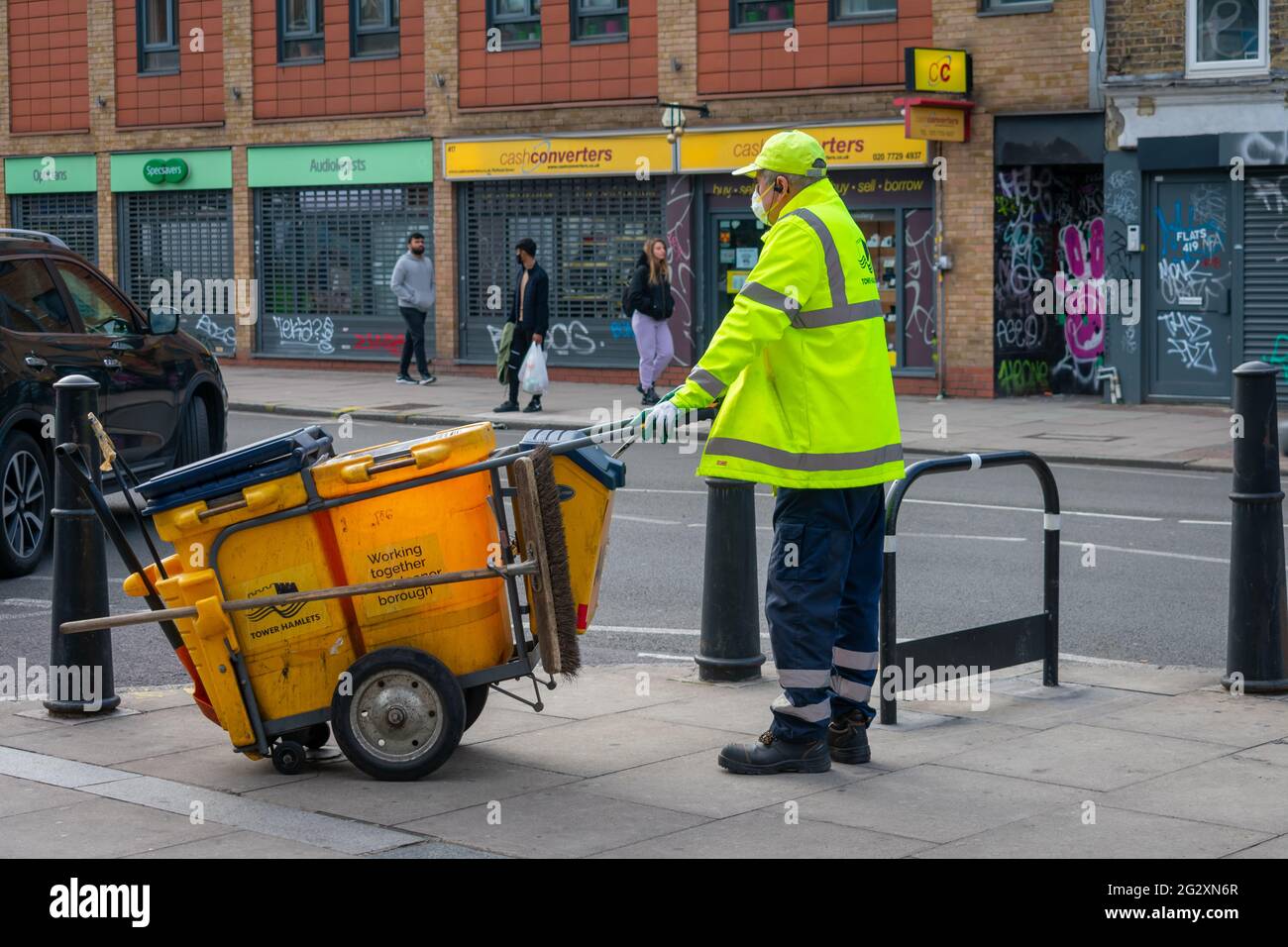 London. UK- 05.25.2021. A man working for Tower Hamlet Environmental Services keeping the high street clean. Stock Photo