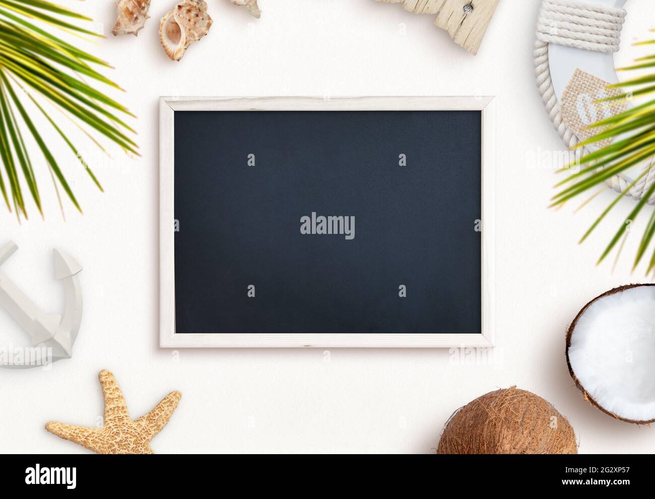 Empty chalkboard surrounded by summer, beach objects. Travel presentation, top view, flat lay composition Stock Photo