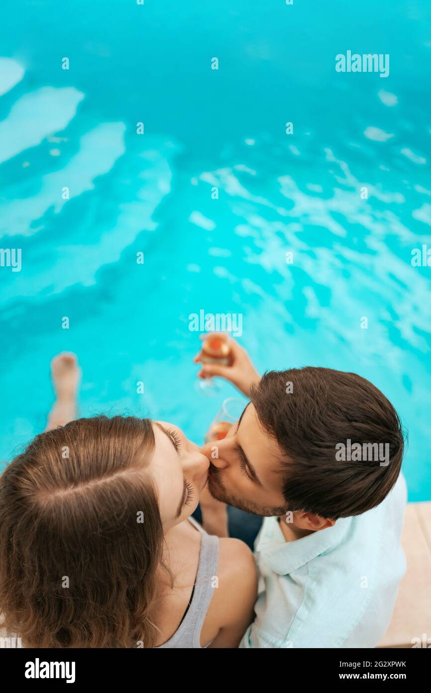 Romantic couple kissing swimming pool hi-res stock photography and