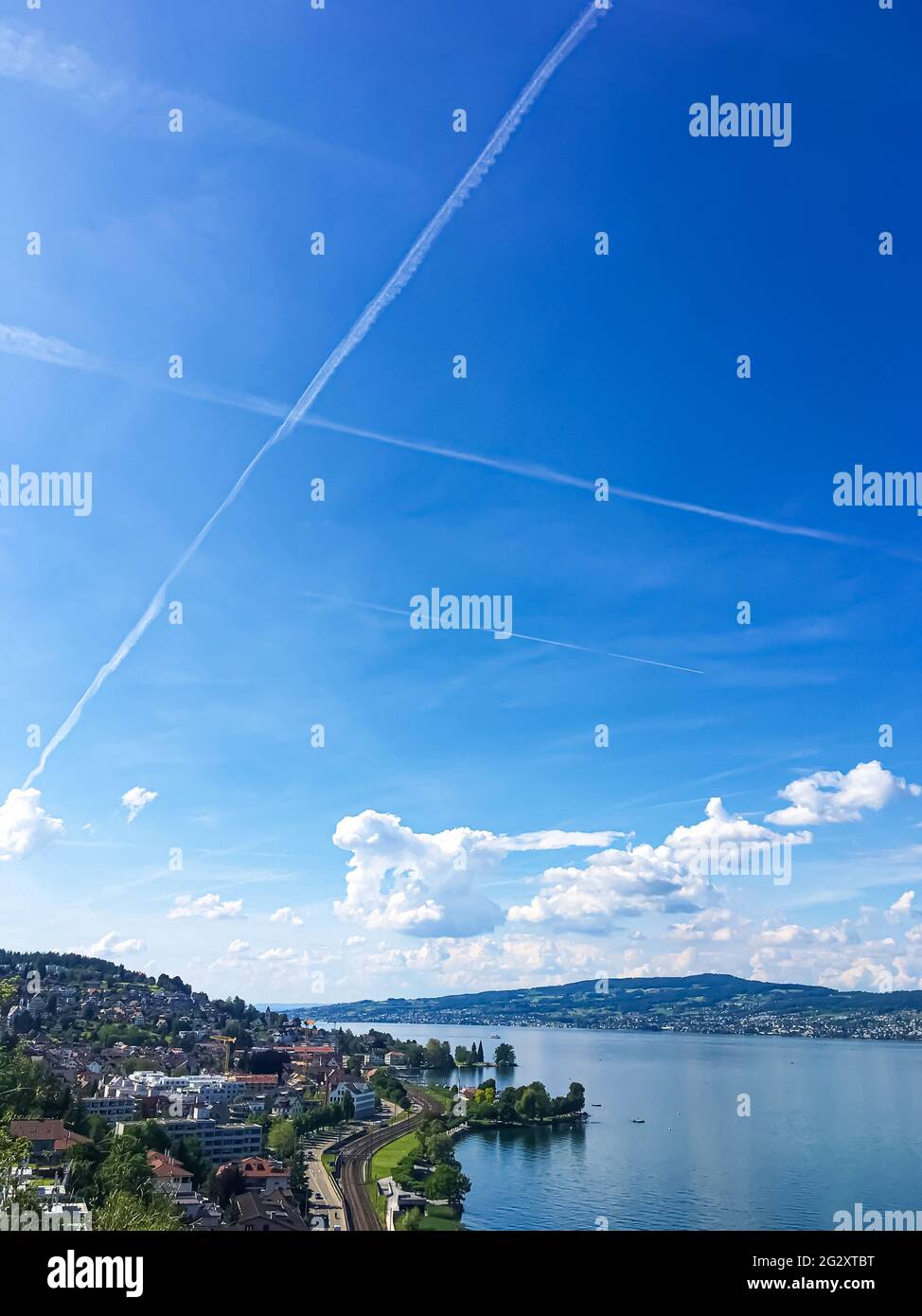 Idyllic Swiss landscape, view of lake Zurich in Richterswil, Switzerland, mountains, blue water of Zurichsee, sky as summer nature and travel Stock Photo