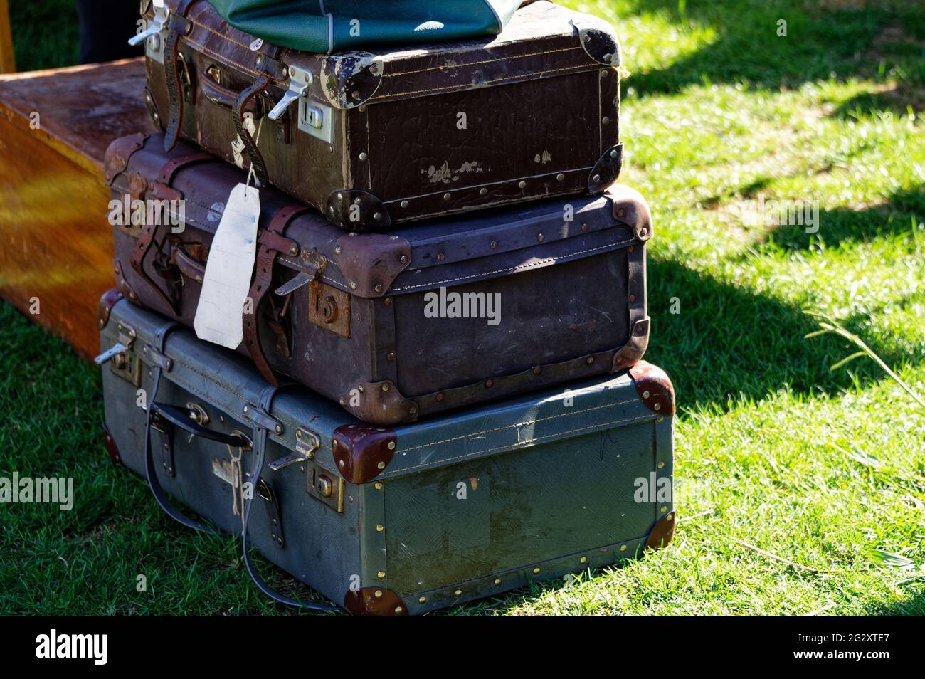 A pile of suitcases on the grass Stock Photo