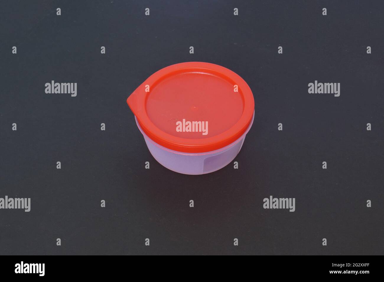 Round Plastic container in a dark background Stock Photo