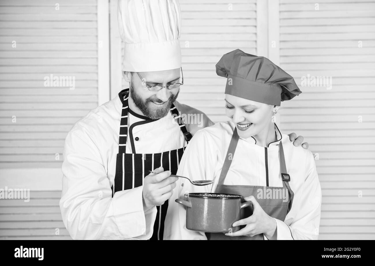 Couple having fun while whipping cream. Woman and bearded man chef cooking together. Cooking healthy meal. Delicious meal. Baking pie together Stock Photo
