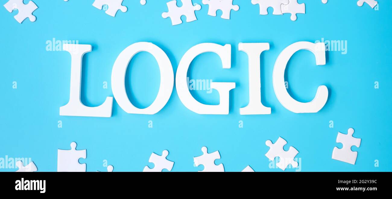 LOGIC text with white puzzle jigsaw pieces on blue background. Concepts of logical thinking, Conundrum, solutions, rational, strategy, world logic day Stock Photo