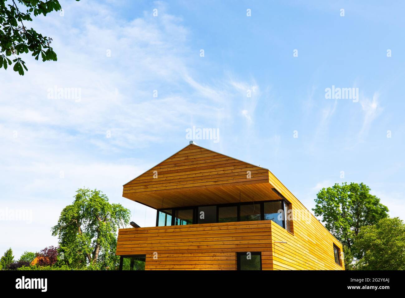 modern wooden house with wooden roof, blue sky Stock Photo - Alamy
