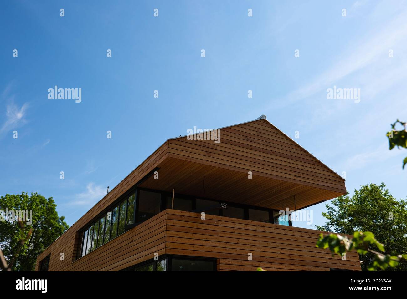 modern wooden house with wooden roof, blue sky Stock Photo - Alamy