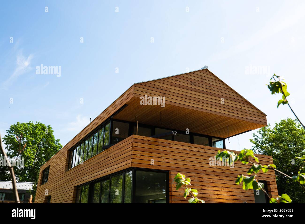 modern wooden house with wooden roof, blue sky Stock Photo - Alamy