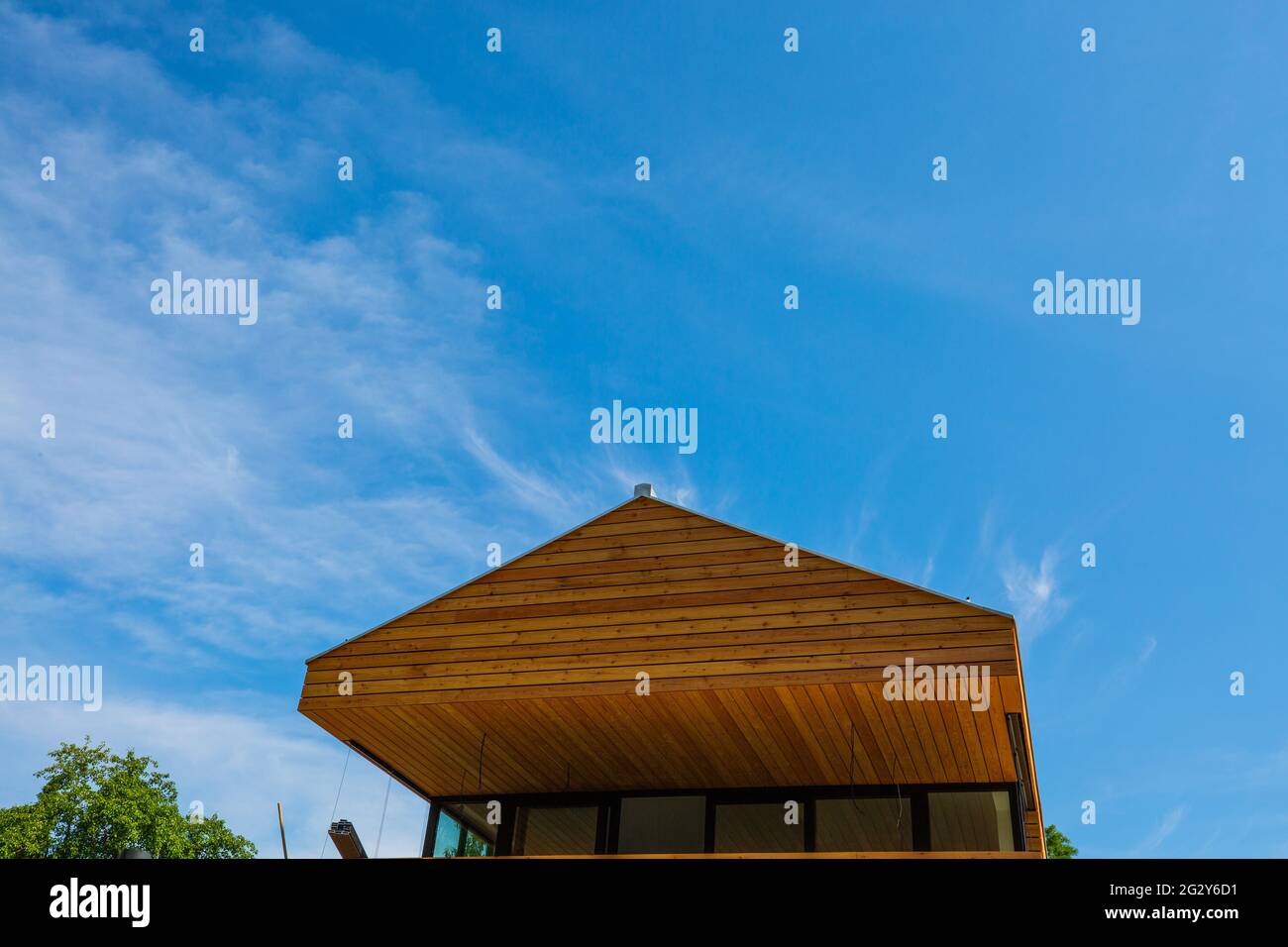 modern wooden house with wooden roof, blue sky Stock Photo - Alamy