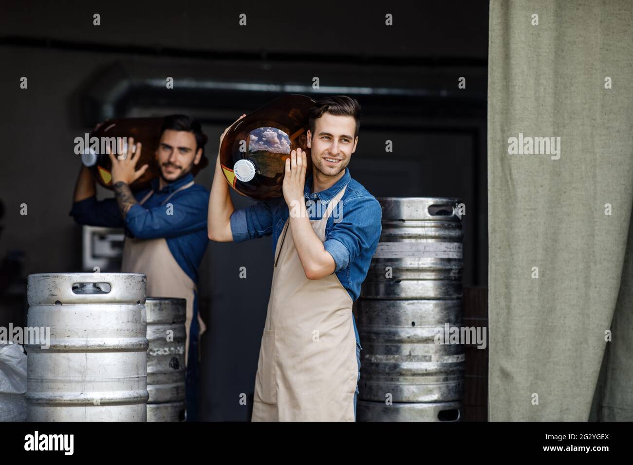 Workers in warehouse of brewery holds ingredients for preparation of