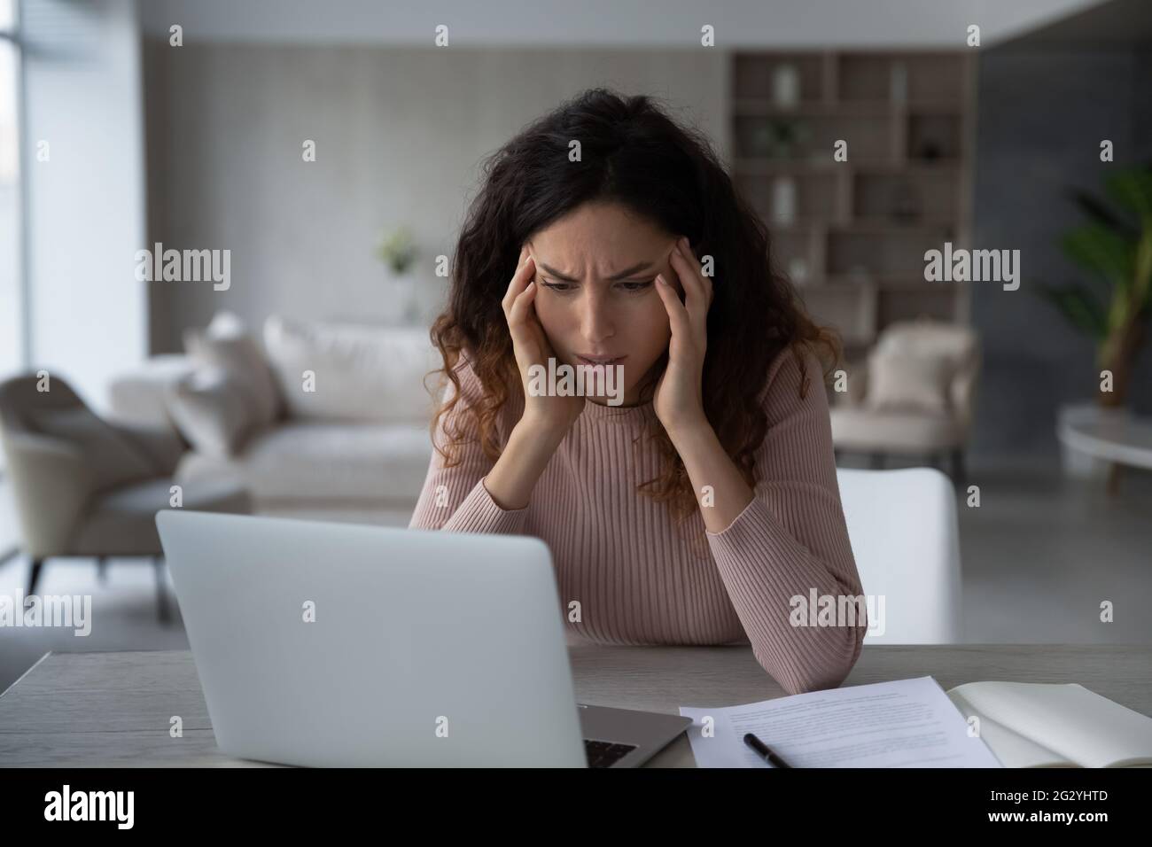 Unhappy Latino woman distressed with work deadline Stock Photo