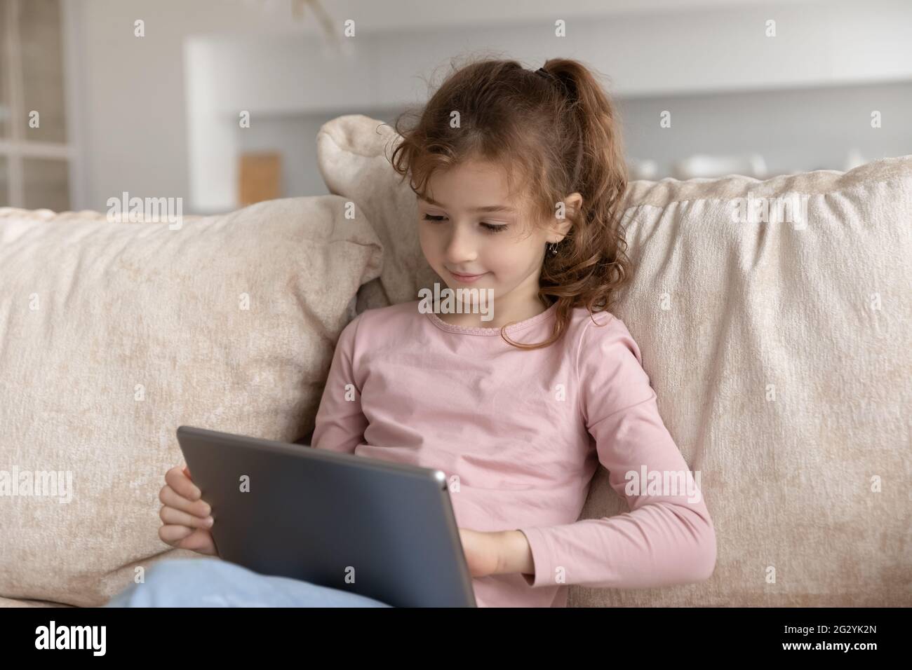 Little biracial girl child use pad at home Stock Photo