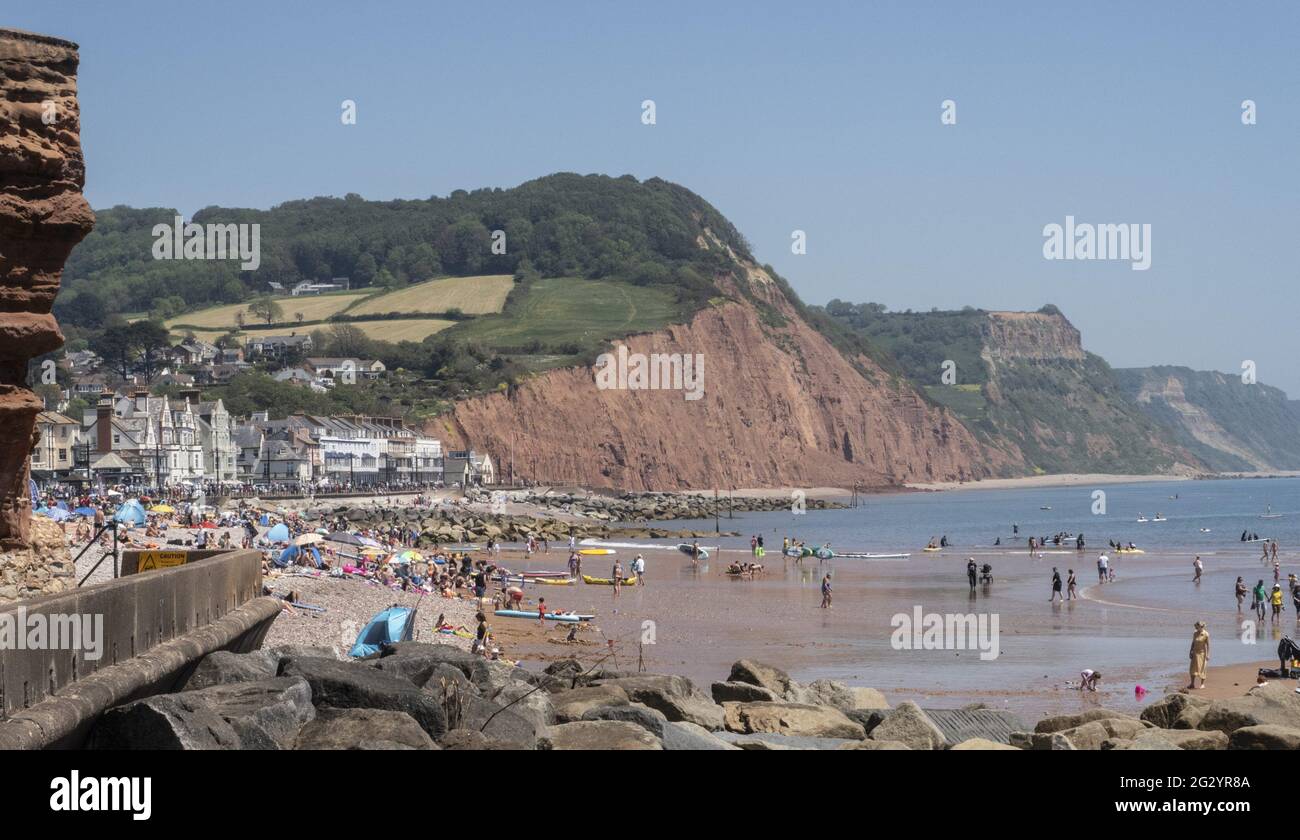 Sidmouth, 13th June 2021. Families enjoy a glorious afternoon in scorching temperatures on the town beach at Sidmouth, Devon. Photro Central/Alamy Live News Stock Photo