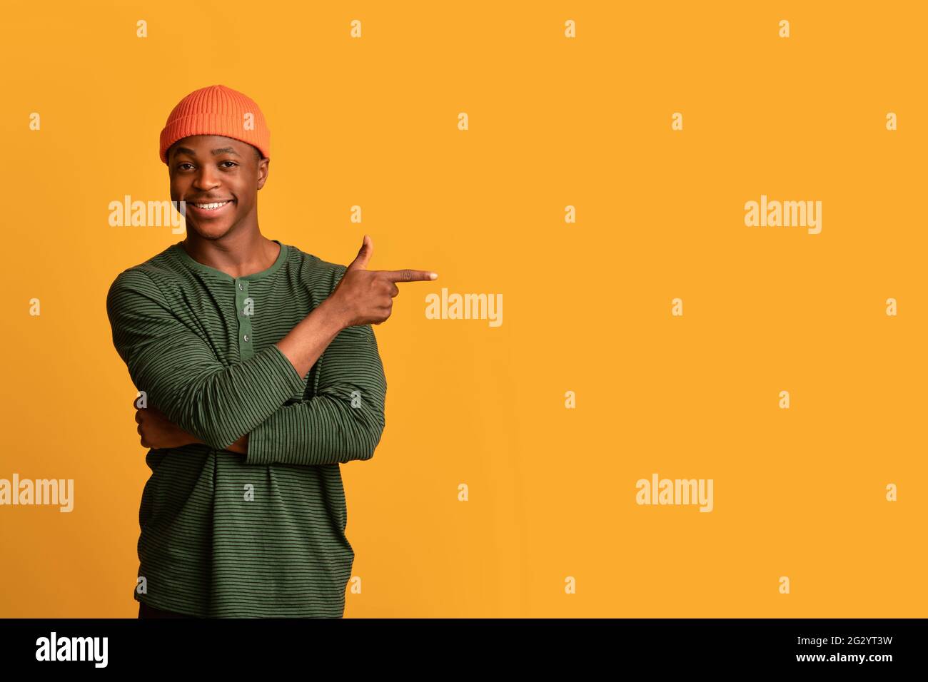 Look At This. Positive Young Black Man Pointing Aside At Copy Space Stock Photo