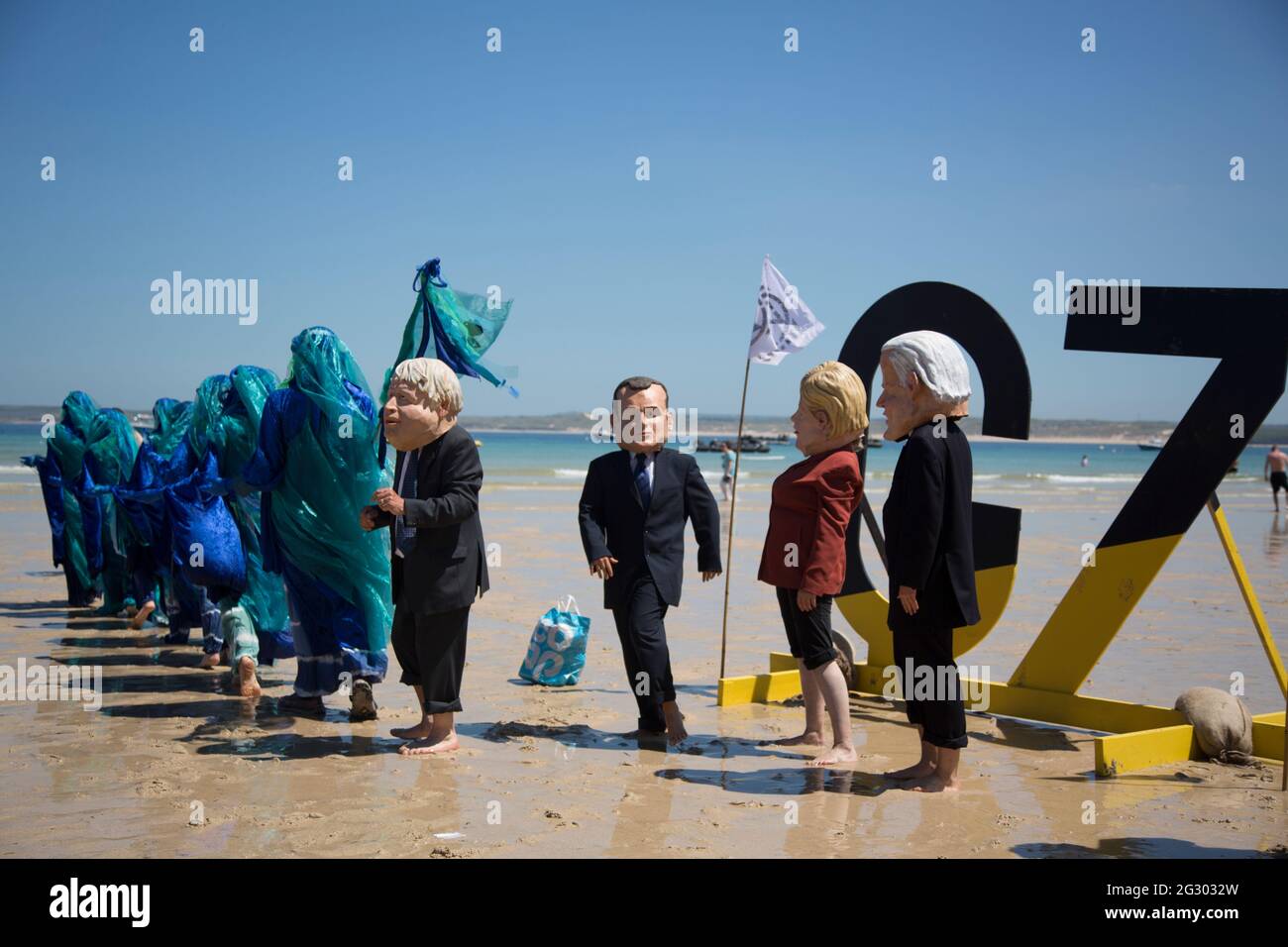 St Ives, UK. 13th June 2021. Extinction Rebellion activists dressed as G7 leaders protest with the Ocean Rebels on Porthminster Beach, St Ives, on the final day of the G7 Summit when climate change dominated the agenda. Credit: Sarah Peters/Alamy Live News Stock Photo