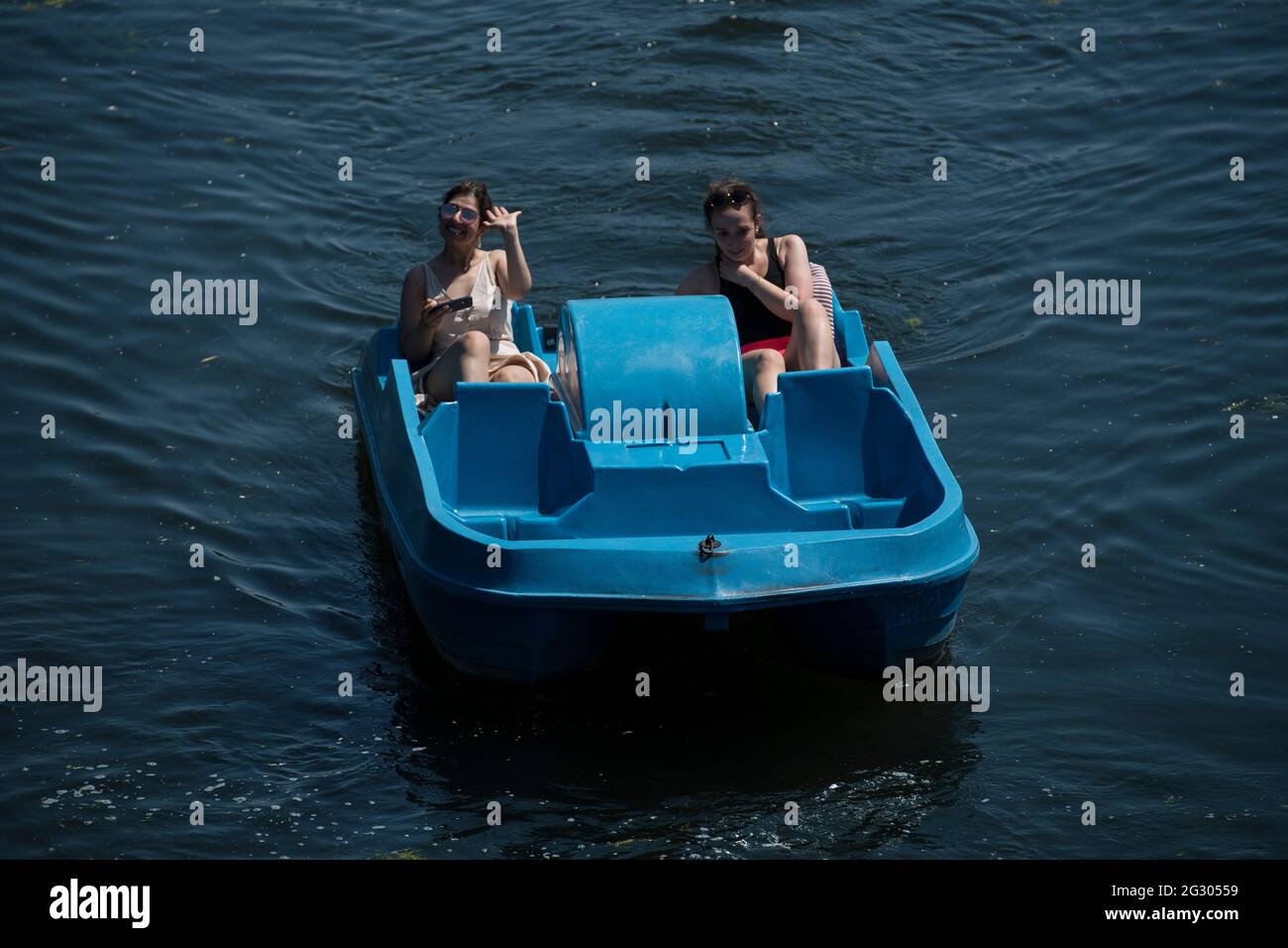 People ride pedalo boats in the hot weather on the Serpentine in Hyde