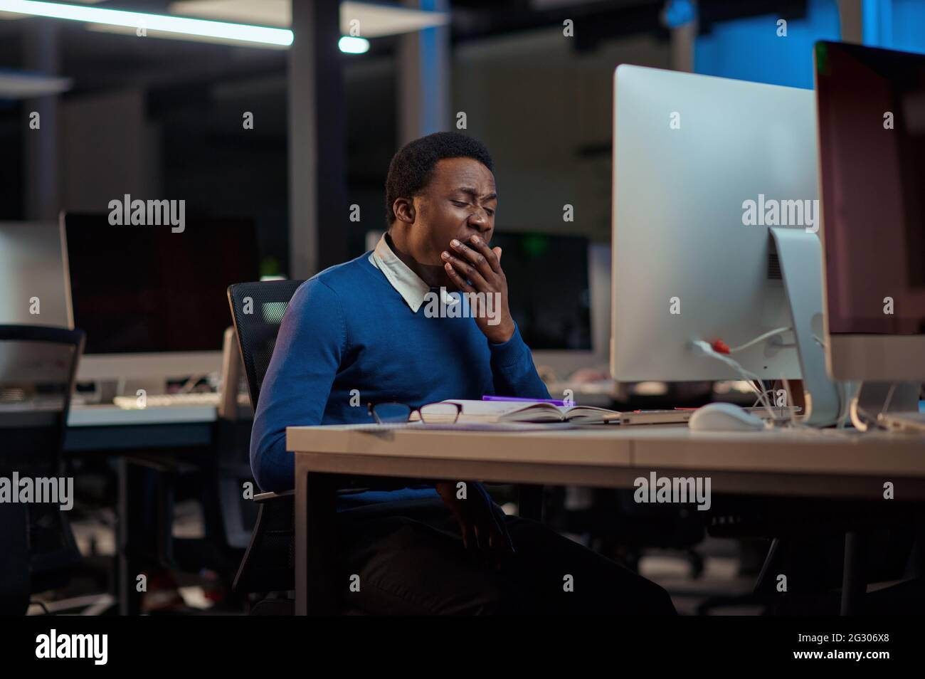 Tired young man works in night office Stock Photo