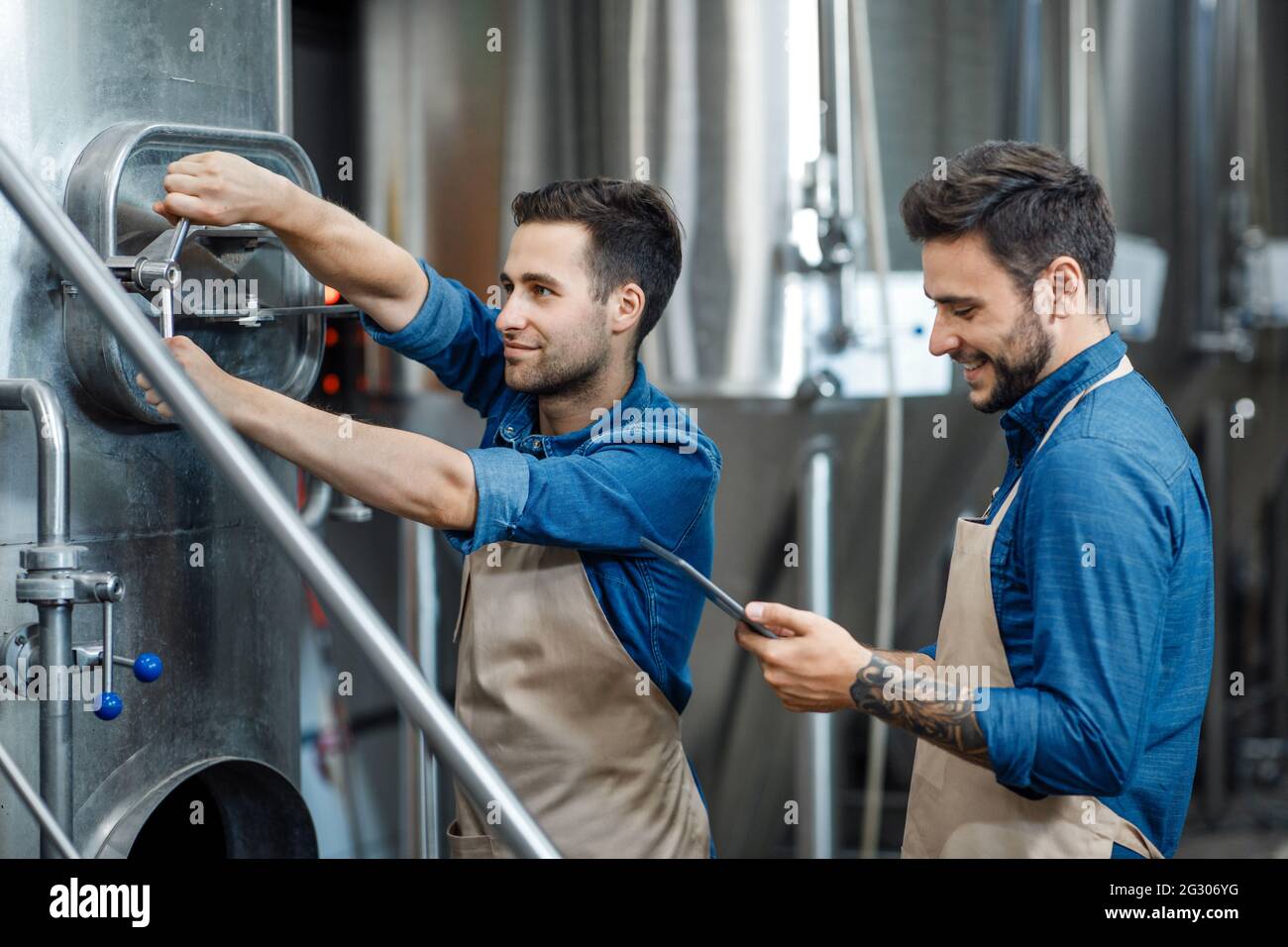 Fermentation process in plant, work of brewer and management of equipment Stock Photo