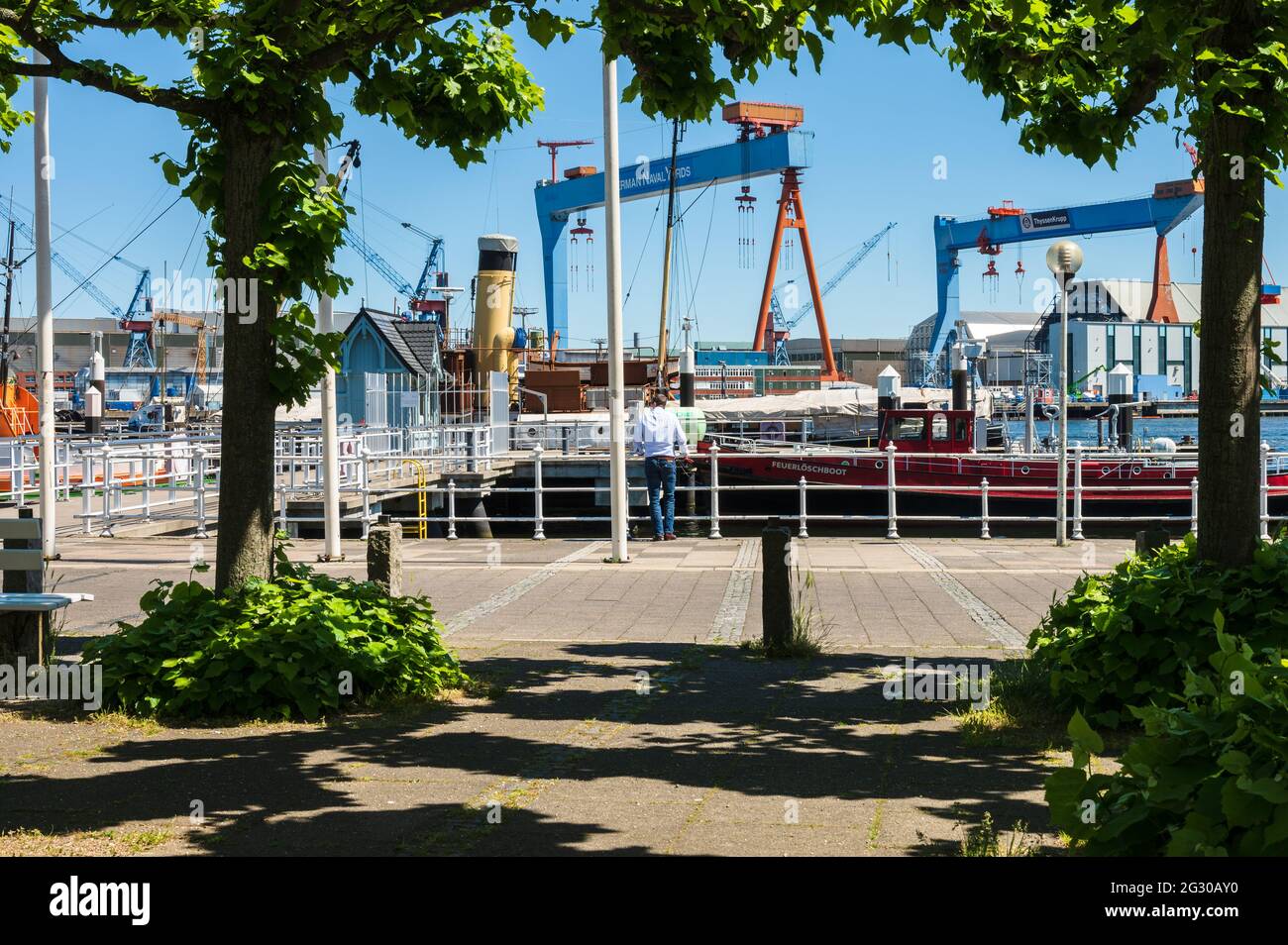 Der Museumshafen an der Seegartenbrücke gegenüber dem Kieler Schloss. Auf dem Ostufer der Kieler Förde die Werftanlagen für den Schiffbau Stock Photo