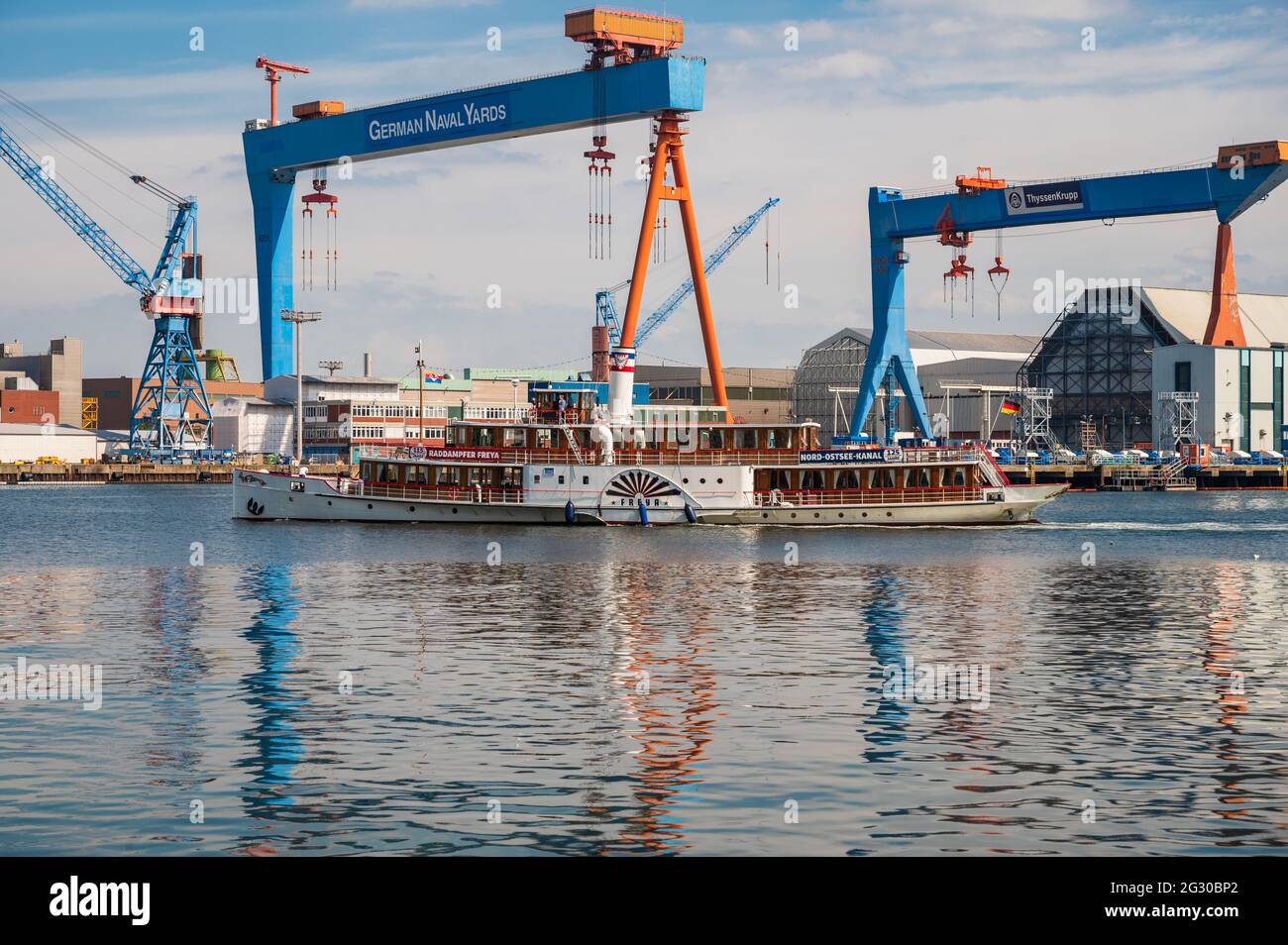 Der Schaufelraddampfer MS Freya vor der Seegartenbrücke in der Kieler Förde passiert die Werftanlagen auf dem Ostufer in Kiel-Gaarden Stock Photo