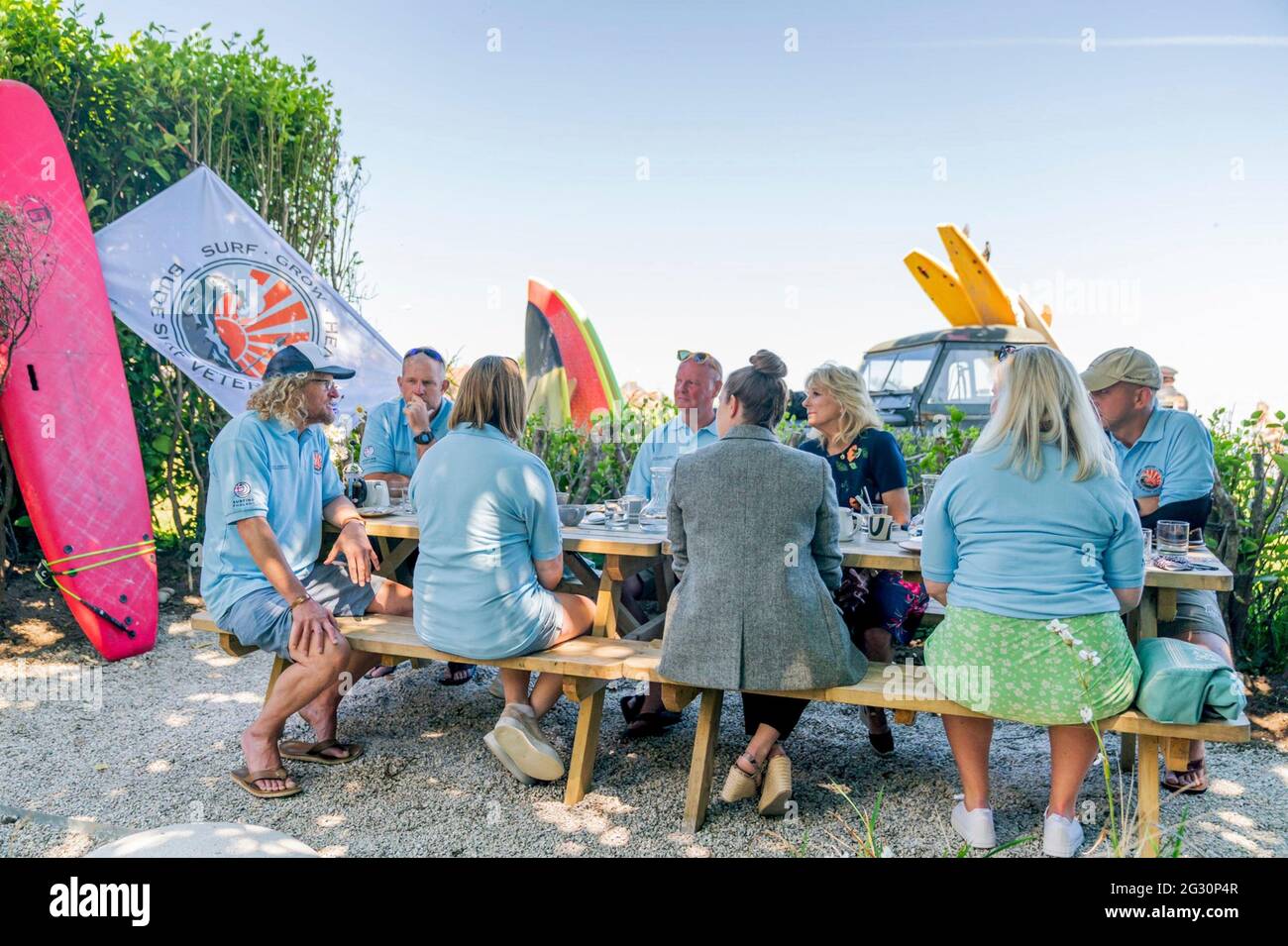 Newlyn, UK. 12th June, 2021. U.S. First Lady Dr. Jill Biden, center, meets volunteer surfers with the Bude Surf Veterans and their families on the sidelines of the G7 Summit along Mounts Bay June 12, 2021 in Newlyn, Cornwall, United Kingdom. Credit: Planetpix/Alamy Live News Stock Photo