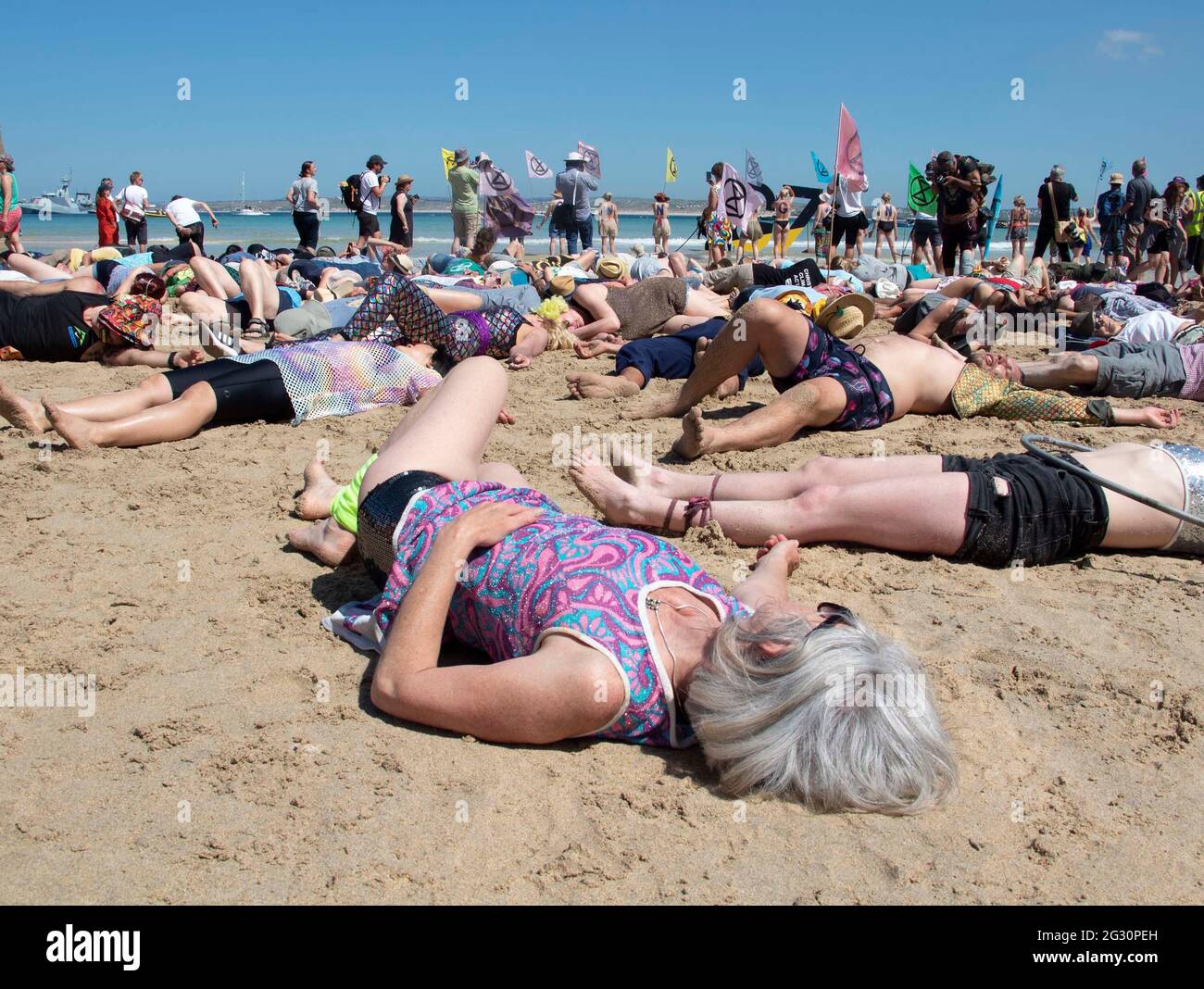 St Ives, Cornwall, UK. 13th June, 2021. An Extinction Rebellion protester takes part in a 'mass die-in' in protest against the climate emergency and the G7 taking place at Carbis bay. 13th June 2021. Anna Hatfield/ Pathos Credit: One Up Top Editorial Images/Alamy Live News Stock Photo