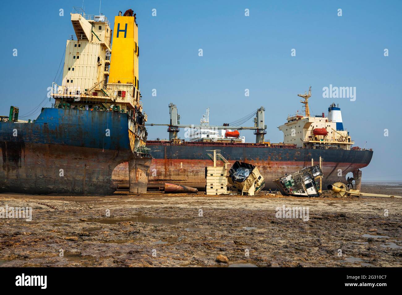 Alang ,01, February, 2016: Wide angle view of ship breaking yard with half cut ship and parts lying on ground,Bhavnagar,Gujarat,India Stock Photo