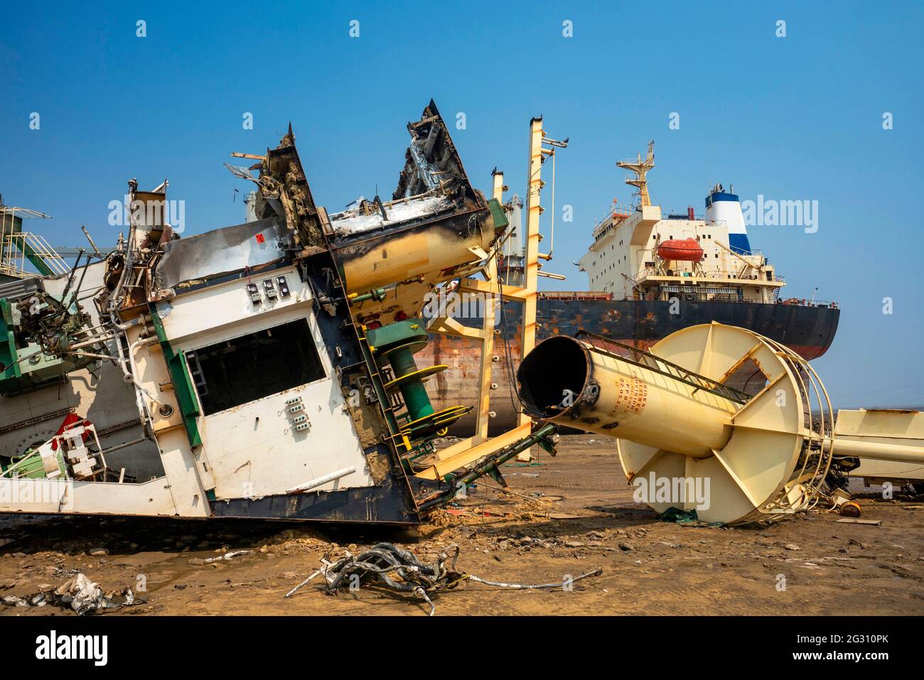 Alang,01,February,2016: Close up of cut parts of the ship lying on ground with ship in background at Ship Breaking Yard ,Bhavnagar,Gujarat,India Stock Photo