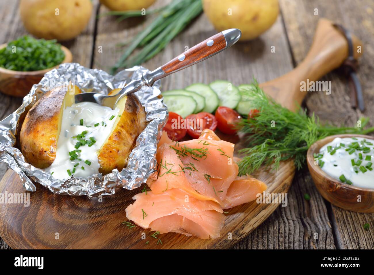 Baked jacket potato fresh from the oven served with chives sour cream and  smoked salmon Stock Photo - Alamy