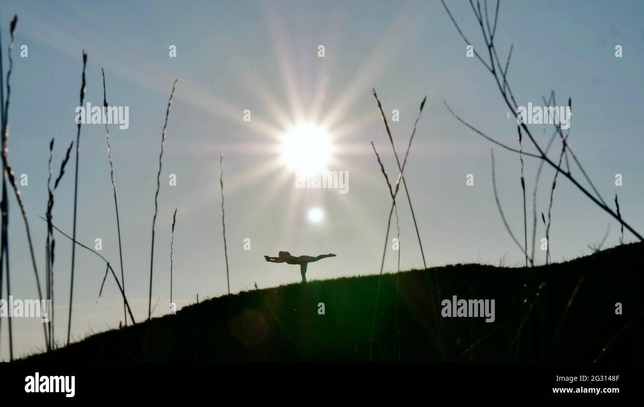 Silhouette of a woman in a yoga pose on sunset Stock Photo - Alamy
