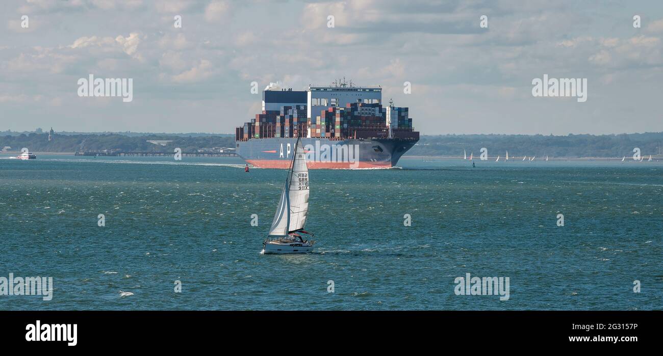 Southampton Water, England, UK. 2021. The container carrier ship APL Vanda underway southbound on Southampton Water approaching a small yacht. Stock Photo