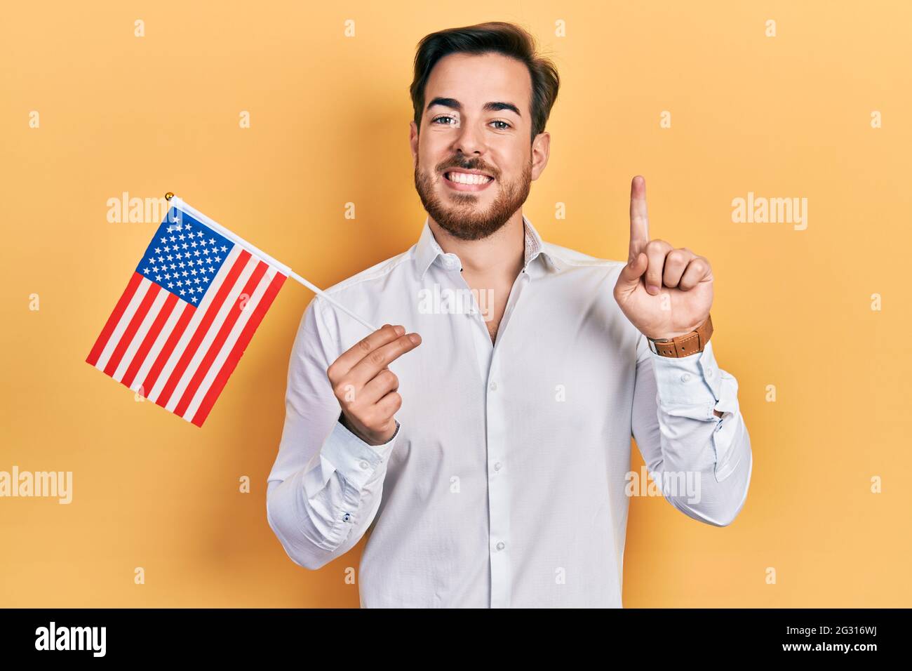 Handsome caucasian man with beard holding united states flag smiling ...