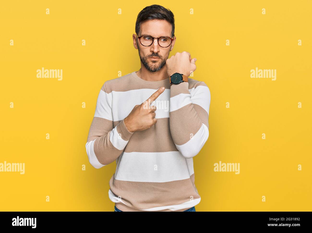 Handsome man with beard wearing casual clothes and glasses in hurry ...